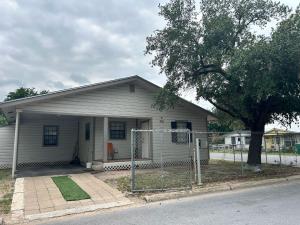 a small white house with a fence in front of it at Sweet Spot in Pharr in Pharr
