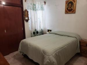 a bedroom with a white bed and a window at Casa vista hermosa in San Juan del Río