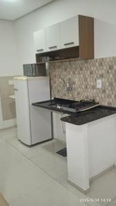 a kitchen with a counter top and a refrigerator at Kitnet Mobiliada in Vitória da Conquista