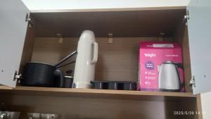 a kitchen shelf with items on it at Kitnet Mobiliada in Vitória da Conquista