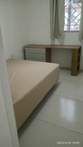 a bed and a desk in a room at Kitnet Mobiliada in Vitória da Conquista