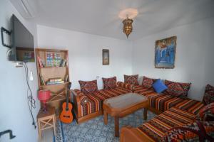 a living room with a couch and a guitar at Dar Al Mansoura RIAD in Chefchaouen