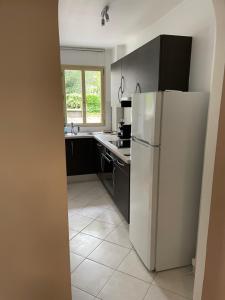 a kitchen with a white refrigerator and a sink at French Welcome in Paris