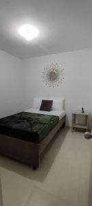a bedroom with a bed and a mirror on the wall at Apartamento Amoblado La Tebaida in La Tebaida