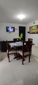 a dining room with a table and chairs and a tv at Apartamento Amoblado La Tebaida in La Tebaida +3 photos