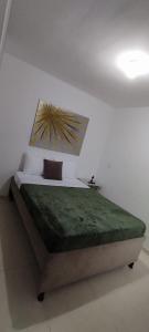 a bedroom with a bed with a green blanket on it at Apartamento Amoblado La Tebaida in La Tebaida