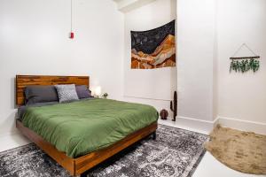 a bedroom with a bed with a green comforter at Urban Retreat in Knoxville