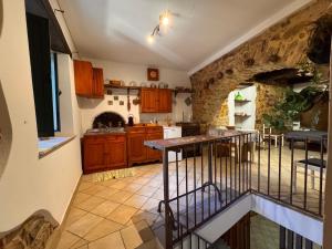 a kitchen with wooden cabinets and a stone wall at Casa centro storico borgo medievale in San Mauro Castelverde +22 photos
