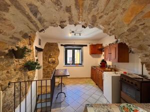 a kitchen with a stone wall in a house at Casa centro storico borgo medievale in San Mauro Castelverde