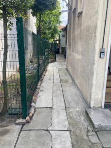 an alley with a fence next to a building at habitat la DHUYS in Montreuil