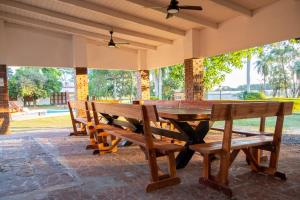 a wooden table and benches on a patio at El Refugio Lodge in Corrientes