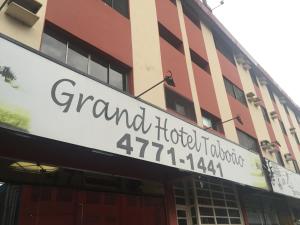 um sinal para um hotel em frente a um edifício em Grand Hotel Taboao em Taboão da Serra