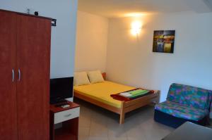 a small room with a bed and a chair at Apartmani Tomar in Star Dojran