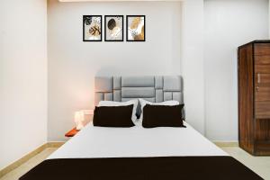 a bedroom with a large white bed with two pillows at Super Hotel O Sweetheart Luxurious Rooms in Patancheru +35 photos