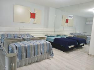 a bedroom with two beds and a painting on the wall at Saint Sebastian Flat 213 - Com Hidro! até 4 pessoas, Duplex, no centro in Jaraguá do Sul