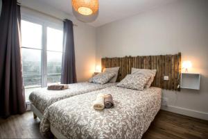 a bedroom with a bed with shoes on it at Villa les pepouzes - vue mer - jacuzzi- sauna in Plouescat