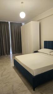 a bedroom with a large bed and a large window at 3 Modern Apartments for big groups or families in Orikum