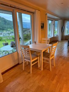 a dining room with a table and chairs and windows at Stryn Central View in Stryn