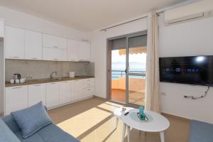 cocina con sofá, mesa y TV en Sea View Luxury Apartments, en Vlorë