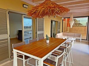 ein Esszimmer mit einem Holztisch und Stühlen in der Unterkunft Serena Luxury House in Caleta de Fuste