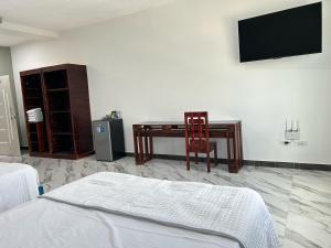a bedroom with a desk and a tv on a wall at Hotel Palace in La Concordia