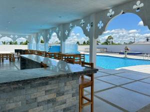 a pavilion with a pool and tables and chairs at Hotel Palace in La Concordia