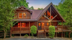 een hut in het bos met een groot terras bij Mountain Magic Holiday home in Gatlinburg