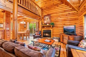 een woonkamer met een bank, een tv en een open haard bij Mountain Magic Holiday home in Gatlinburg