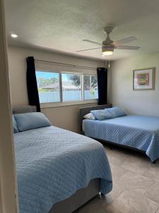 a bedroom with two beds and a ceiling fan at Pool house in Englewood in Englewood