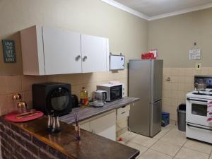 a kitchen with a refrigerator and a microwave at Large 1 bed apt for long term stay in Klerksdorp +1 photo