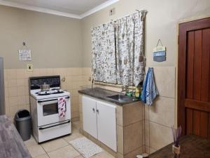 a small kitchen with a stove and a sink at Large 1 bed apt for long term stay in Klerksdorp