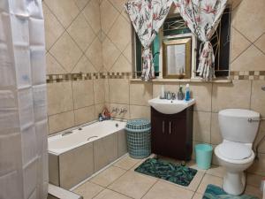 a bathroom with a tub and a toilet and a sink at Large 1 bed apt for long term stay in Klerksdorp