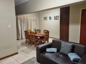 a living room with a couch and a table and chairs at Large 1 bed apt for long term stay in Klerksdorp