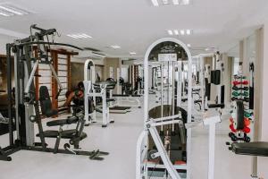 a gym with a lot of treadmills and machines at Duplex no In Mare Bali by Qavi in Granja Beira Mar