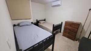 - une chambre avec 2 lits et une commode dans l'établissement Casa Garcia Lomas, à Ciudad Valles