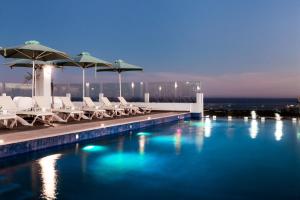 a swimming pool with chairs and umbrellas on a building at Comfort Inn & Suites Los Cabos in Cabo San Lucas +31 photos