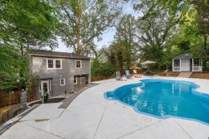 a swimming pool in a backyard with a house at Hilltop retreat - Large pool in Woodlawn