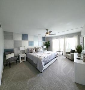 a bedroom with a bed and a chair and a couch at Blue By The Bay in Panama City Beach