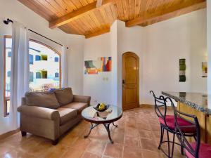 a living room with a couch and a table at Rosarito Puerto Nuevo Surf 1BR casita and pool in Raulis +10 photos