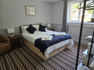 a bedroom with a bed with two towels on it at The Benett Arms in Shaftesbury
