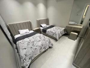 アル・コバールにあるNesmat Albaharの鏡付きの部屋にベッドが2つある
