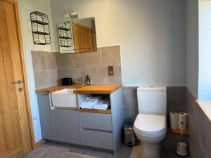 a small bathroom with a toilet and a sink at The Sidings, Wool in Wareham +12 photos