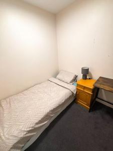 Un dormitorio pequeño con una cama y un escritorio. en Imperial Garden3, en Auckland