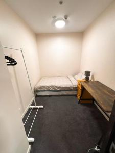Una habitación con una cama y un escritorio. en Imperial Garden3, en Auckland 7 fotos más