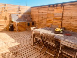 a wooden table and chairs on a wooden deck at Tipi Palette Spa la K abane in Blandin