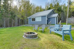 un cortile con un focolare e una casa blu di Waterfront Roque Bluffs Hideaway with Private Beach a Machias