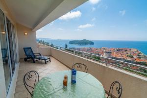 balcón con mesa, sillas y vistas al océano en Apartments Simic en Dubrovnik