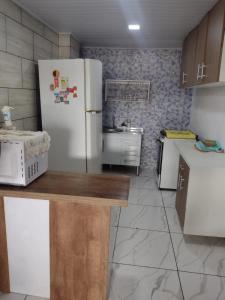 a kitchen with a white refrigerator and a sink at Casa com 2 quartos in Rio das Ostras