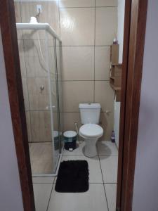 a bathroom with a toilet and a shower and a rug at Casa com 2 quartos in Rio das Ostras