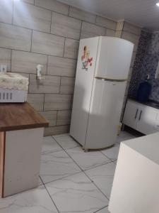 a kitchen with a white refrigerator in a room at Casa com 2 quartos in Rio das Ostras